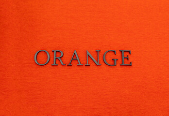 Closeup to an orange spanish word black lettering over an orange texture at background. Color and...
