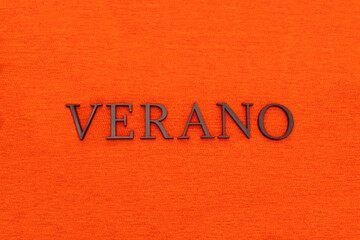 Closeup to a summer spanish word black lettering over orange texture at background. Seasonal and...