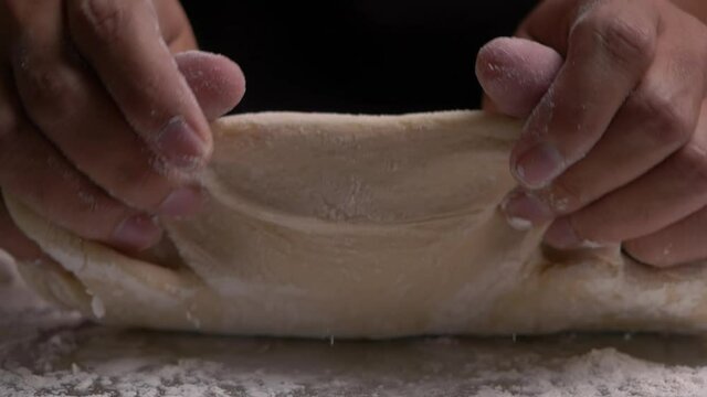 Baker kneading dough on table, Close-up and slow motion