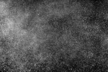 Abstract splashes of water on black background. Freeze motion of white particles. Rain, snow overlay texture.
