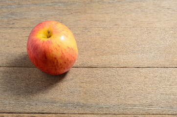 A ripe Apple against the background of textured dashboards is made in a rustic style. Selective focus.