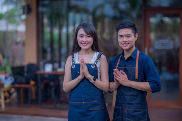 Portrait of male and female coffee shop owner standing in front of the Counter