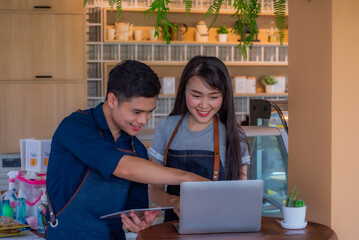 Portrait of male and female coffee shop owner standing in front of the Counter