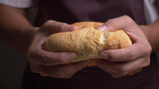 Male hands breaking fresh bread
