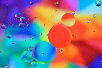 Macro close-up of oil mixed with water. Oil mix with water in colorful background.