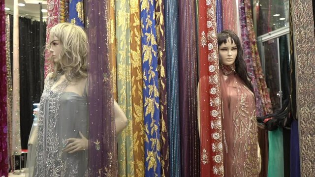 Fabric and dress shop in traditional arabic oriental bazaar marketplace, close up slowmotion
