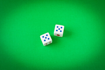 Dice on a green playing table. Close up. The concept of luck in gambling.