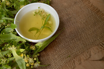 Tea from linden. Fresh flowering linden on a wooden background. Healthy and natural tea. June linden harvest. Healthy.