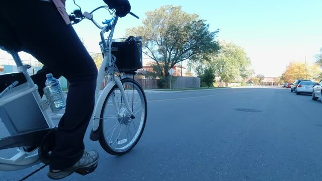 Cyclist riding an electric bicycle in the urban city area. Ecology concept. Shot from the side.