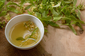 Tea from linden. Fresh flowering linden on a wooden background. Healthy and natural tea. June linden harvest. Healthy.