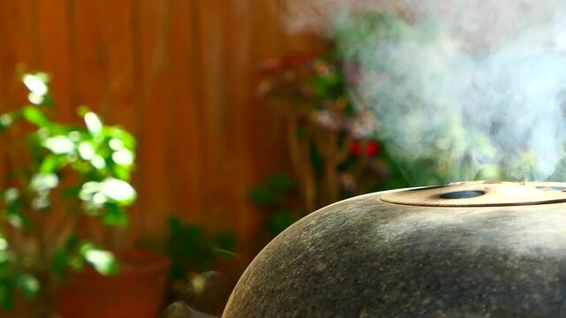 Smoke billowing from a BBQ while meat is cooking