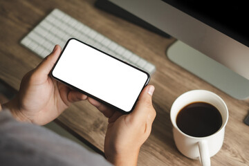 Top view Mockup image hand using a smartphone man Holding Cell Phone With Blank Screen