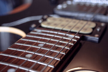 closeup to a six electric guitar strings, wooden fretboard and microphones . Instruments and music...