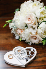 Wedding bouquet of white roses and gold rings