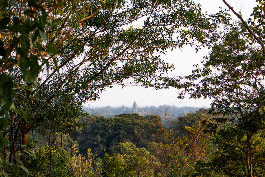 Angkor wat khmer temple pictured from the forest surrounded by trees and nature, views from the elephant walk. Angkor area, Siem Reap, Cambodia, South east Asia