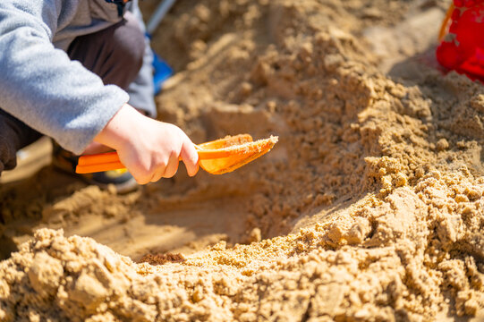 Pupil At Montessori School Playing In Sand Pit.