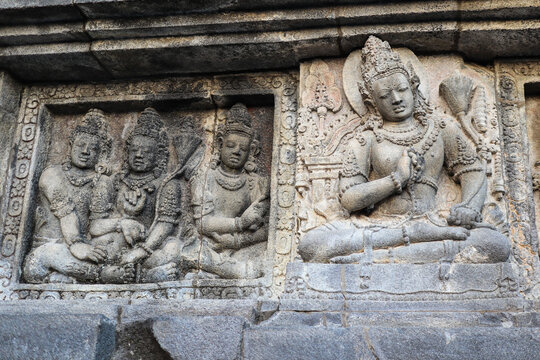 Wall carvings on stone at Prambanan hindu temples. Three sitting figures on lotus posture. Temples located close to the city of Yogyakarta, island of Java, Indonesia, Southeast Asia