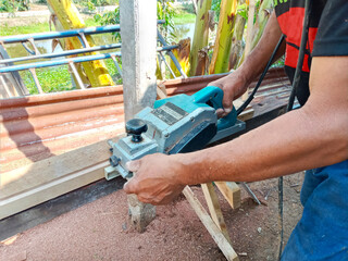 Carpentry planing wood with an electric planer