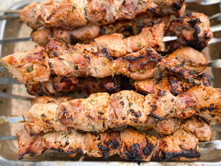 Cooking fried meat on skewers in the summer.Defocus light background.
