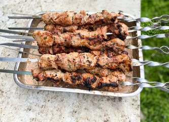 Cooking fried meat on skewers in the summer.Defocus light background.