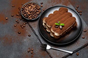 Classic tiramisu dessert on ceramic plate on concrete background