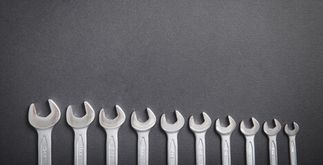 Different sizes wrenches on the black background.
