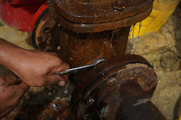 Leaking pipe and rusty stand meter are being repaired