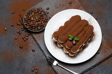 Classic tiramisu dessert on ceramic plate on concrete background