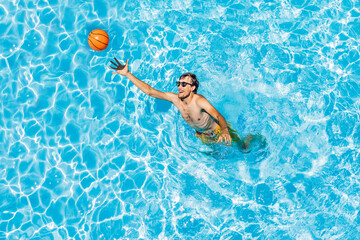 Man play in the pool with a beach ball