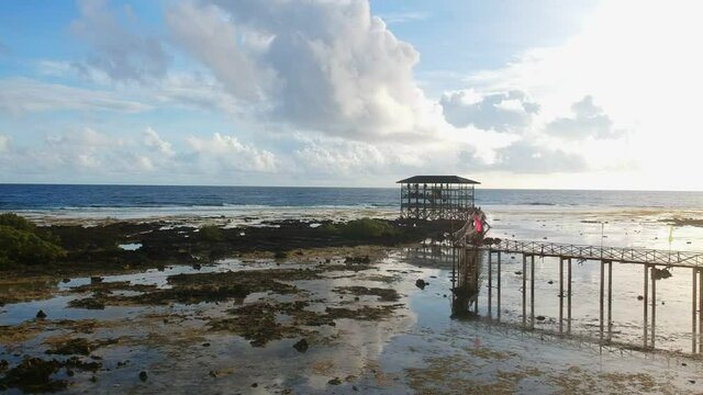 Panning up drone shot of Cloud9 surfing tower in Siargao
