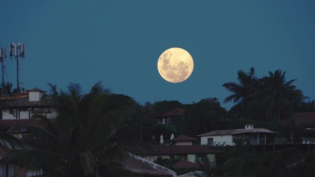 LUA CHEIA NASCENDO SOBRE MORRO COM CASAS