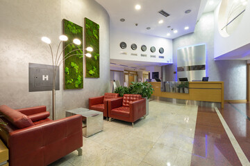 Interior of a hotel lobby with shiny marble floor in the evening