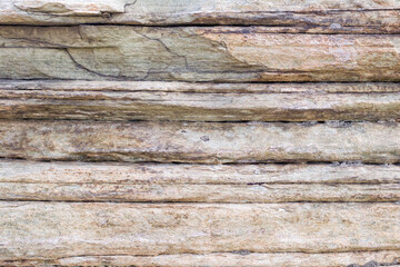 Relief of large gray rock, multi-storey layered rough sedimentary rocks. Natural big stone background, close up texture of layers of stone surface.
