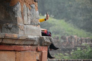 a girl taking a selfie behind a pillar