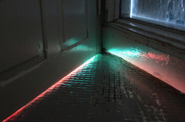 Light in strange colors seen coming from under a door.