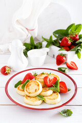 Cheese pancakes, fritters or syrniki with fresh strawberry and yogurt. Healthy and tasty breakfast