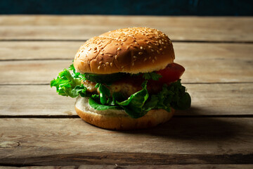 Fresh home-cooked appetizing tasty burger with chicken on wooden table