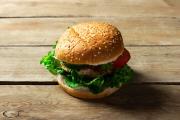 Fresh home-cooked appetizing tasty burger with chicken on wooden table