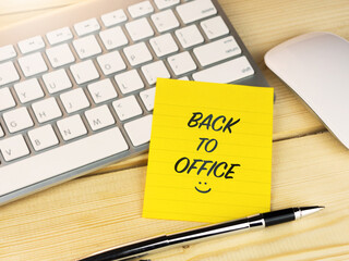 Back to office text with smiley face icon on work desk