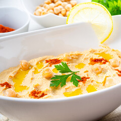 hummus paste with lemon and chilli on white background