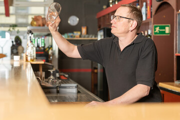 bartender checks whether a glass is clean