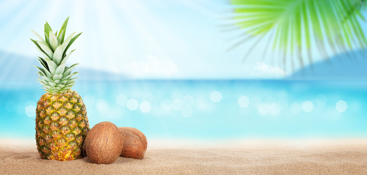 Summer tropical sea with sparkling waves, pineapple and coconuts
