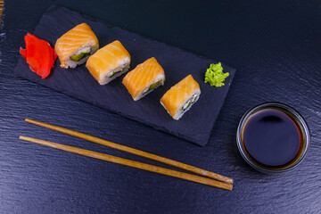 Sushi rolls Philadelphia on a black slate. Top view