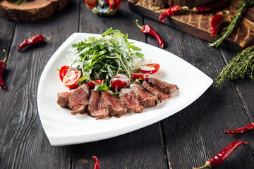 Gourmet roast beef with arugula and tomato salad