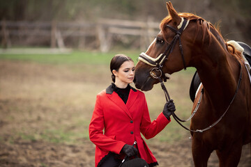 Obraz premium Beautiful woman jockey rider with brown horse outdoors