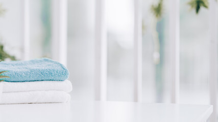 Stack of clean soft towels on blurred background