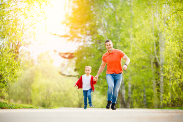 Obraz premium Happy family sport concept. Father and son run together on road in summer park