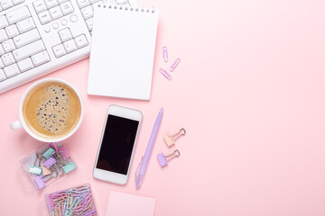 Fashion blogger workplace with cup of coffee on pink background, flat lay, top view. Copy space for your text