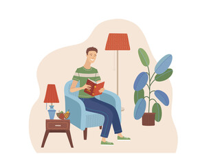 Young man reading book in armchair