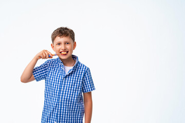 Happy 7-year-old Caucasian boy, smiling, brushing his teeth
